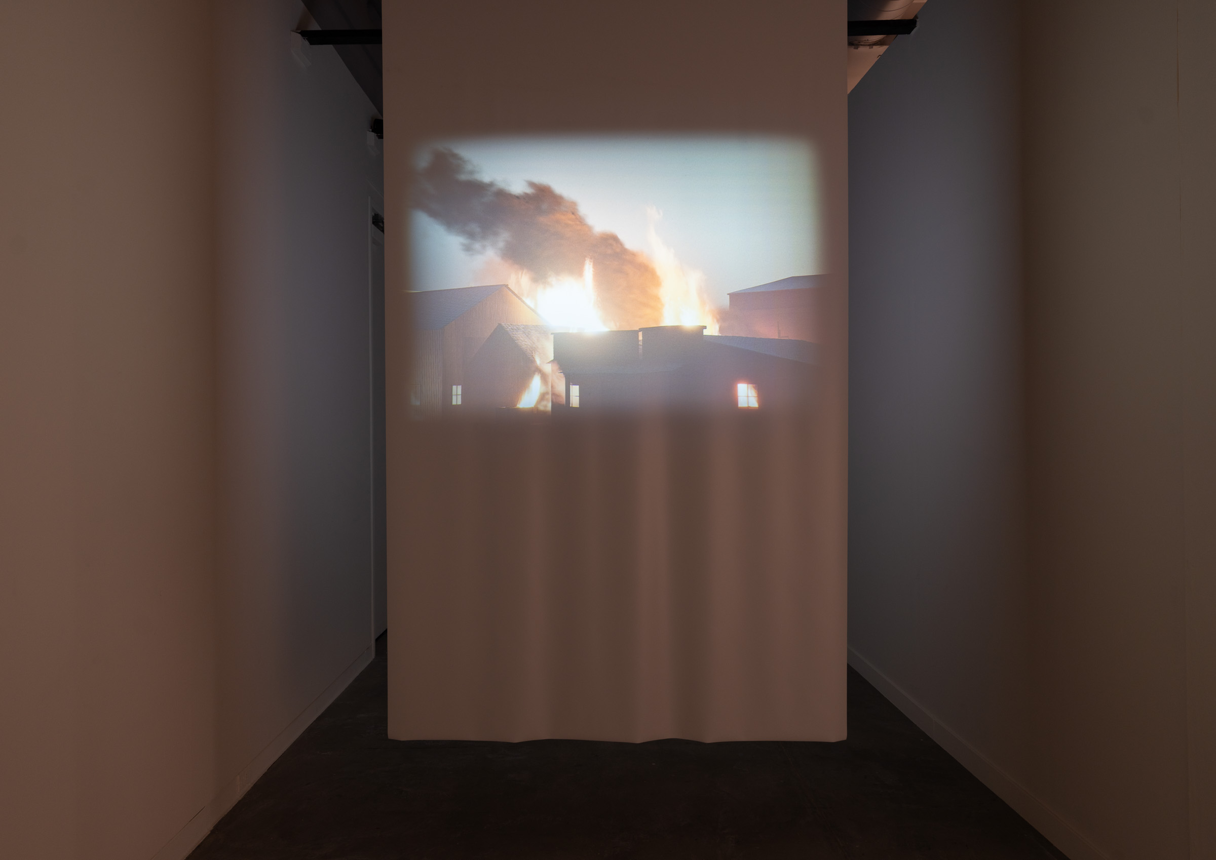 Projection viewed through narrow corridor created by partition